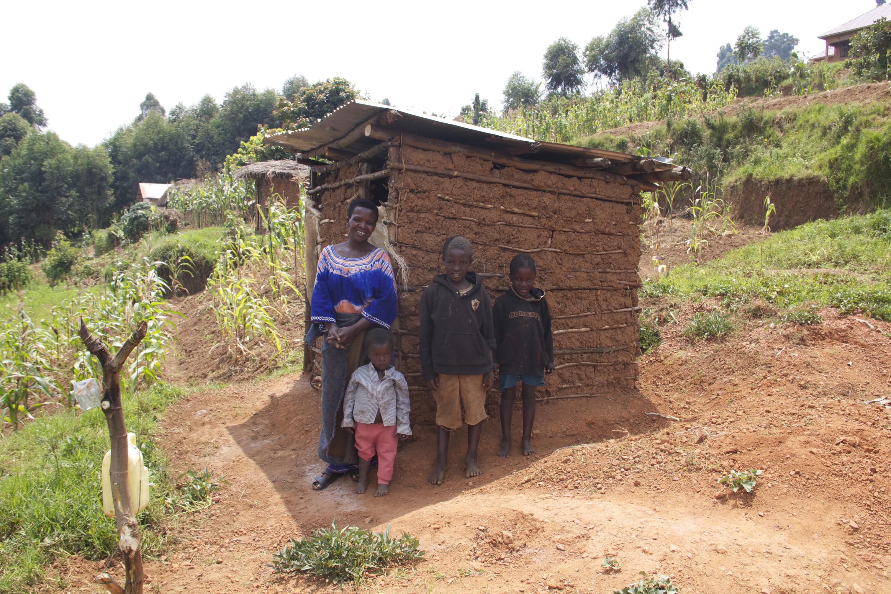 Justine and her family in Uganda with their local latrine